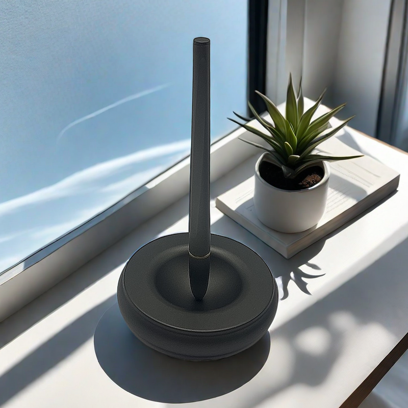 Magnetic levitating pen stand matte grey ceramic base on windowsill with plant lifestyle