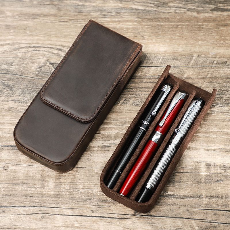 Vintage leather pen case with pull-out tray on wooden table